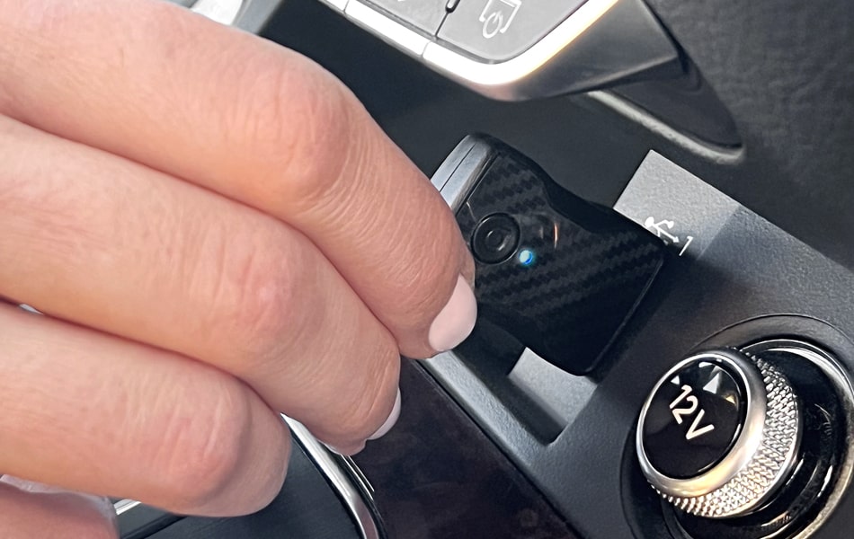 Hand adjusting a wireless Aluratek carplay adapter.